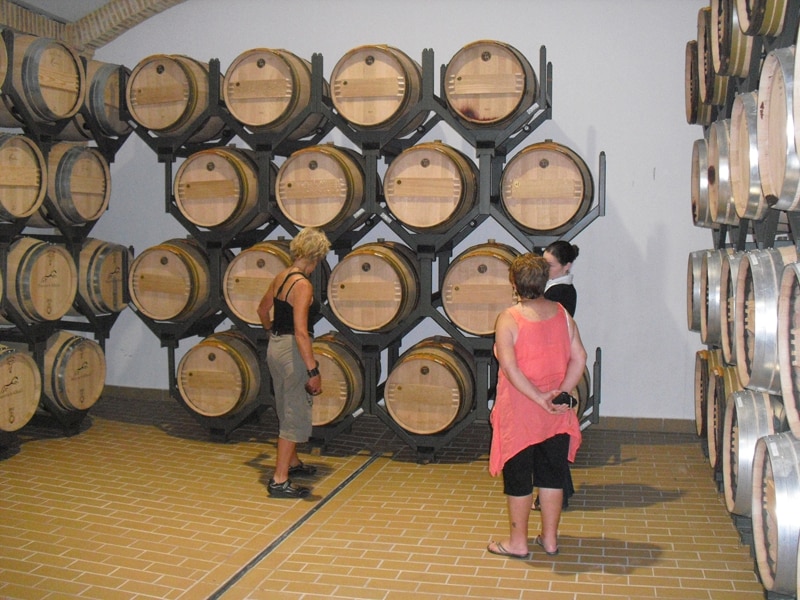 A group visiting a barrel room at a wnery