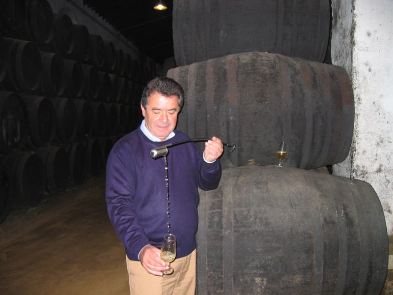 A man pouring sherry using a venencia