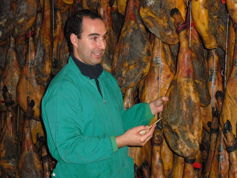 A worker testing an iberico ham to see if it is ready